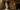 Weddings_masthead_image An image of a married couple stood within the doorway from the Grand Hall East Corridor into the Grand Hall. They hold hands, the groom on the left wearing a grey suit and pink bow tie, and the bride wearing a long white wedding dress, her train delicately flowing to her side.