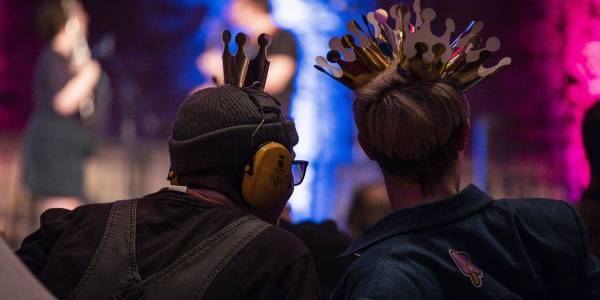 batterseaartscentre_relaxedvenueevent_7thfeb2020_96 The back silhouette of two figures one wearing ear defenders and the other wearing several paper crowns.