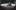 Look At Me Dont Look At Me A black and white image of a figure with long dark hair wearing a grey sheet sits in a large white bathtub filled with water.